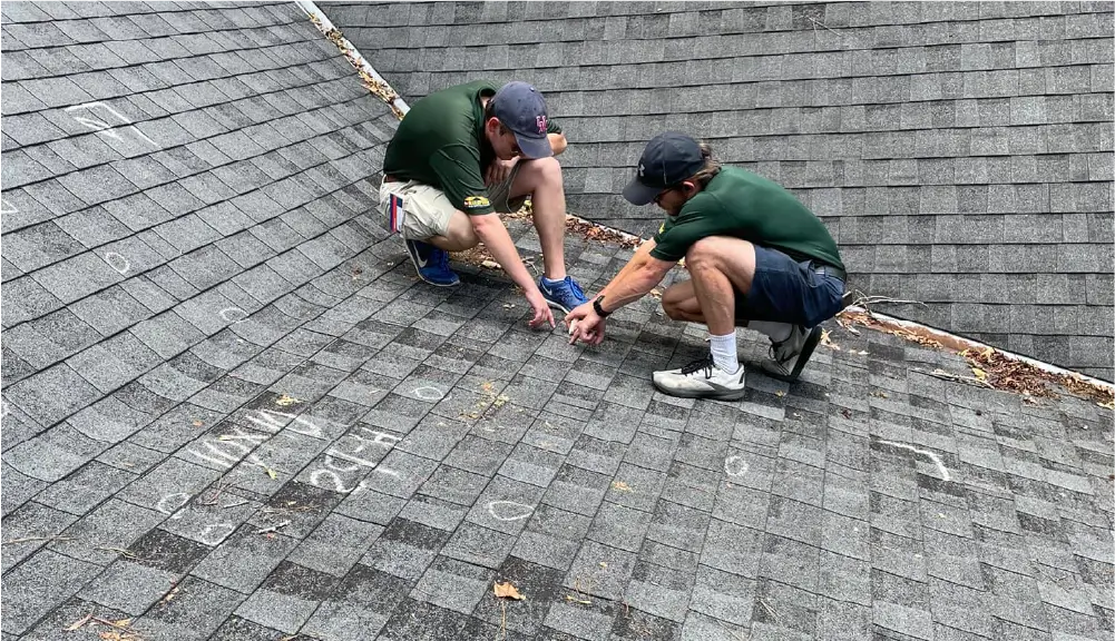 Image of a Continental Roofing inspector assessing hail damage on a roof