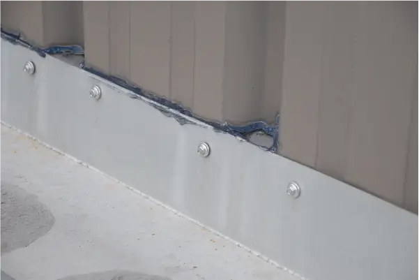 Image of commercial roof with failing metal flashing