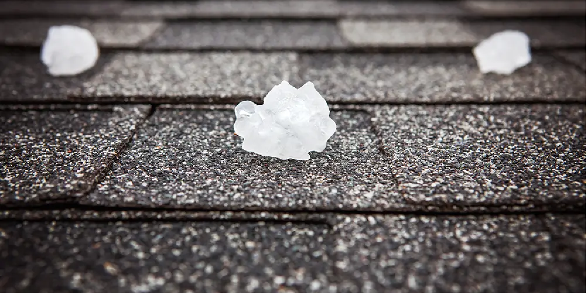 Photo of hail stones sitting on roofing shingles