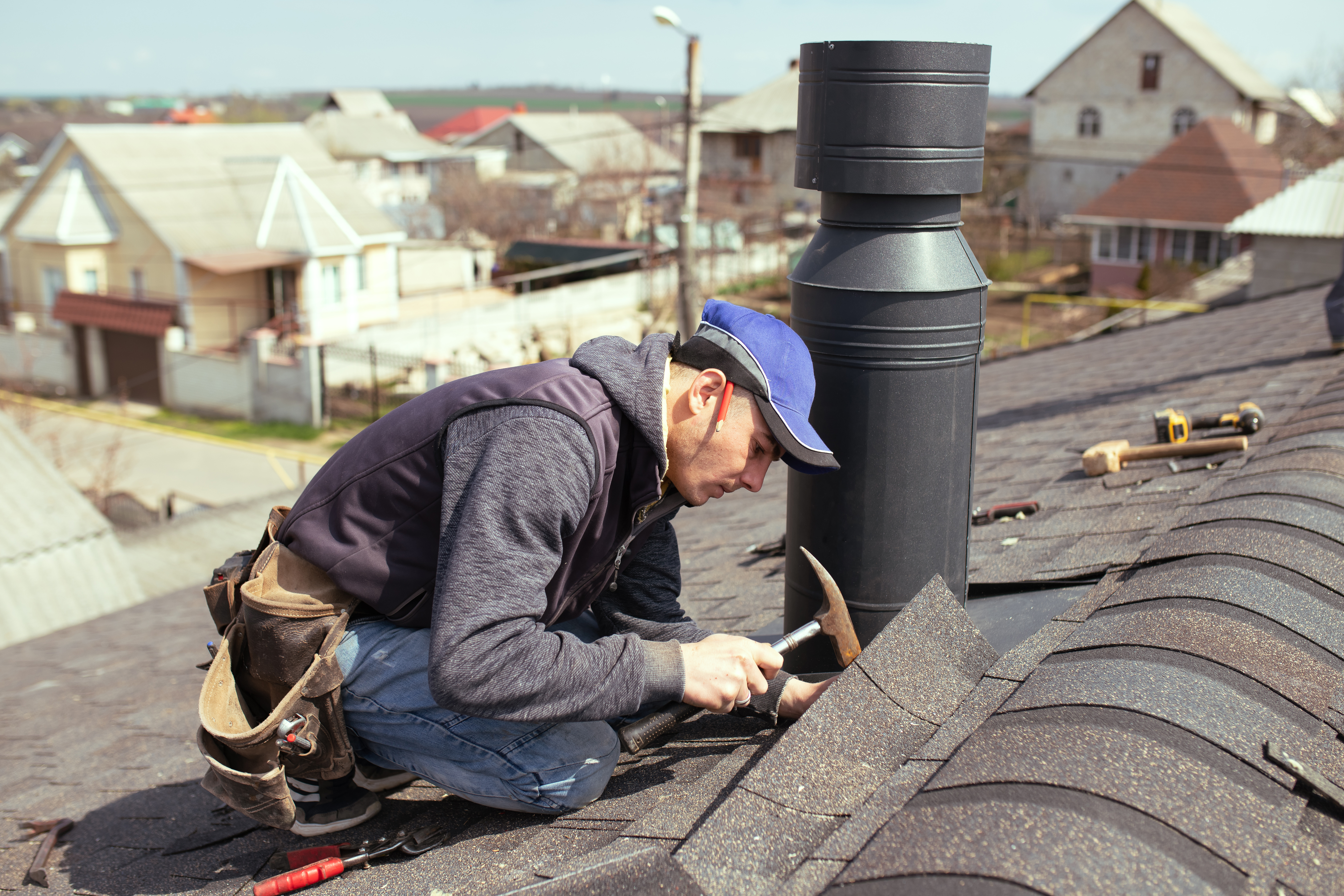 Image of roofing technician repairing a shingle roof
