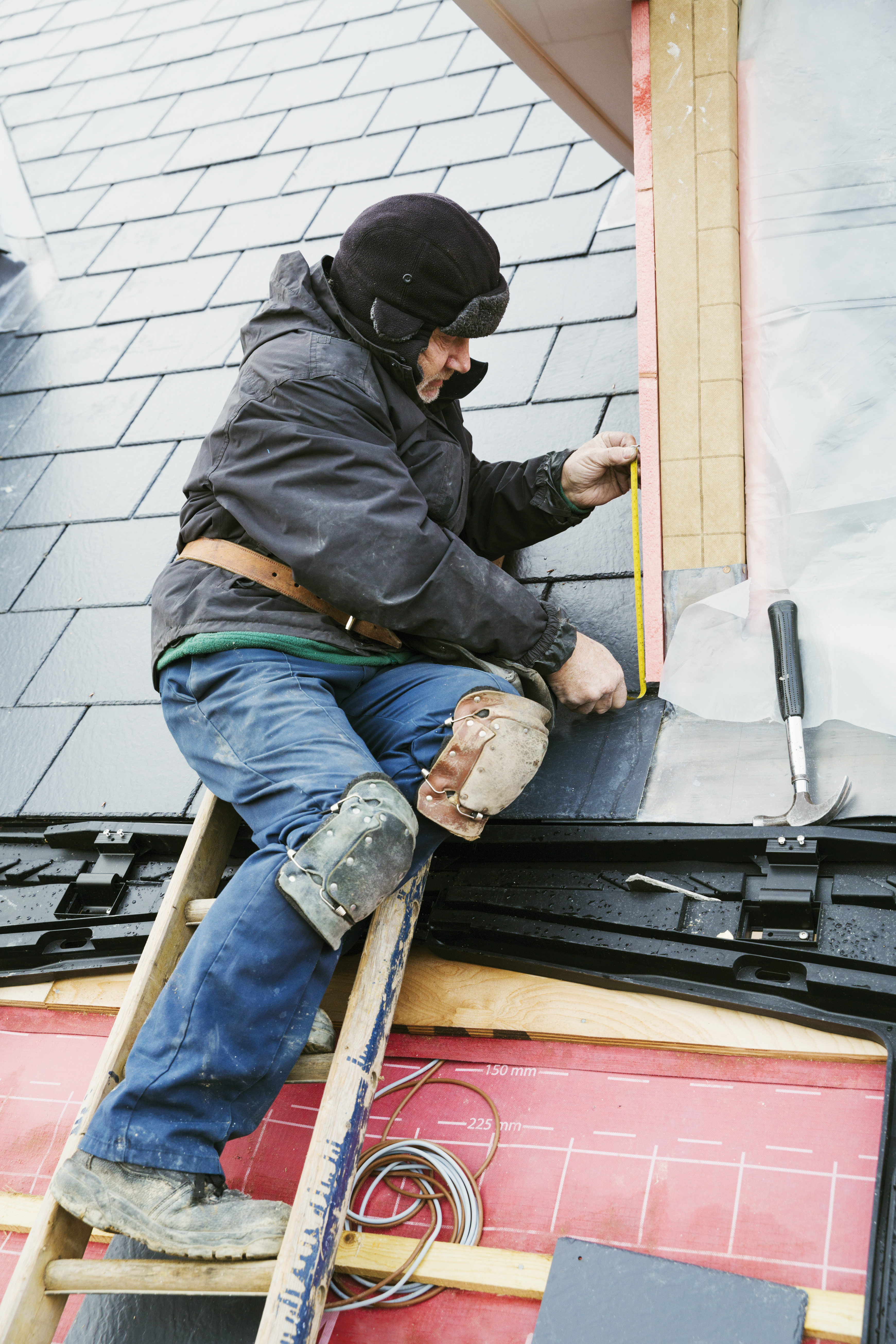 Image of roofing technician repairing a slate roof