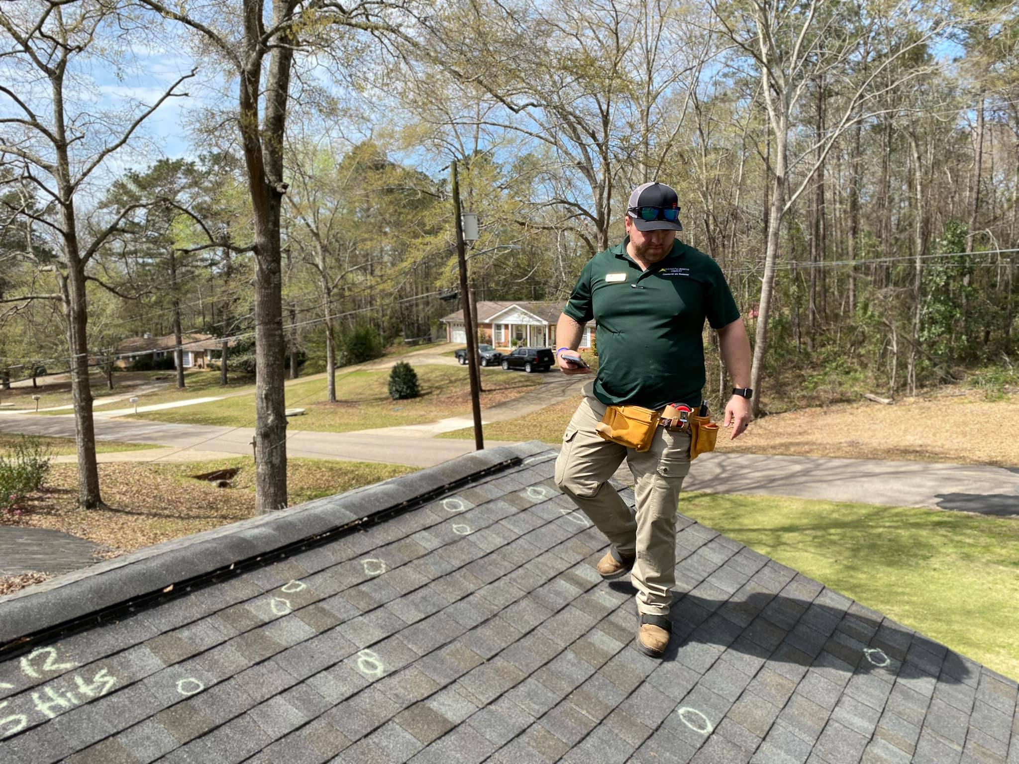 Image of a Continental Roofing inspector assessing hail damage on a roof