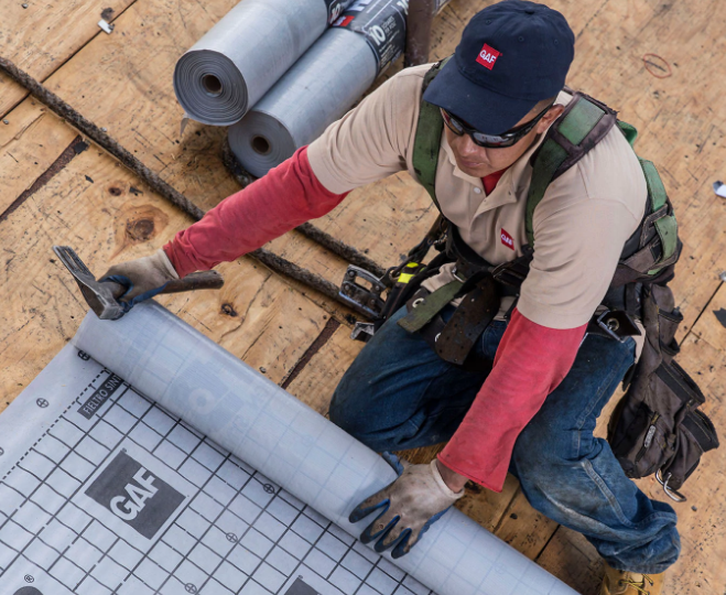 Image of a roofing technician installing synthetic roof underlayment